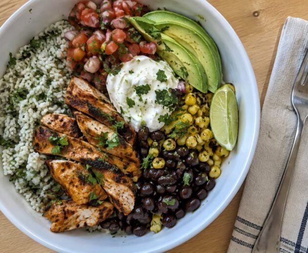 Burrito bowl de pollo al chipotle con arroz cilantro-limón, frijoles negros, elote, pico de gallo y aguacate, receta saludable fácil