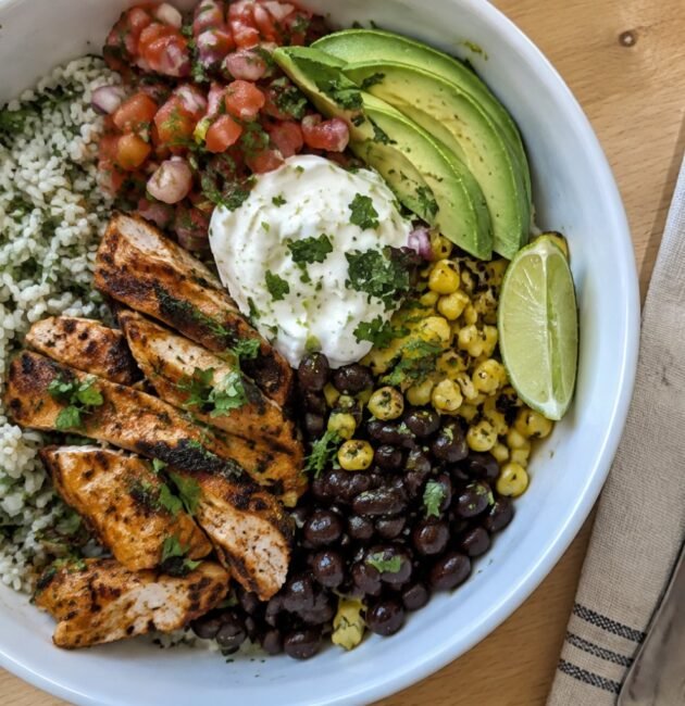 Burrito bowl de pollo al chipotle con arroz cilantro-limón, frijoles negros, elote, pico de gallo y aguacate, receta saludable fácil