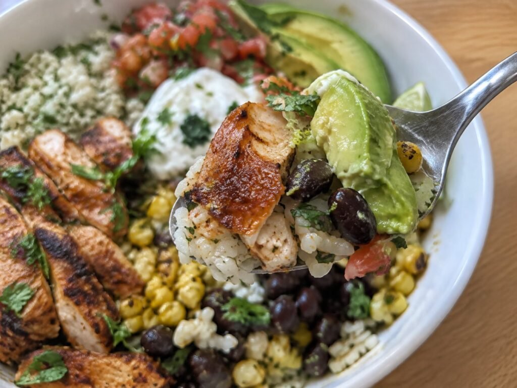 Cuchara con arroz cilantro-limón, pollo jugoso al chipotle, frijoles negros y aguacate cremoso, bowl alto en proteína y fácil