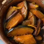 Gajos de calabaza en tacha ligera brillantes en almíbar de piloncillo con canela y naranja servidos en cazuela de barro casera