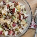 Ensalada de manzana navideña ligera con yogur griego, piña, apio, pasitas y nuez en bowl de cristal, receta fácil y saludable