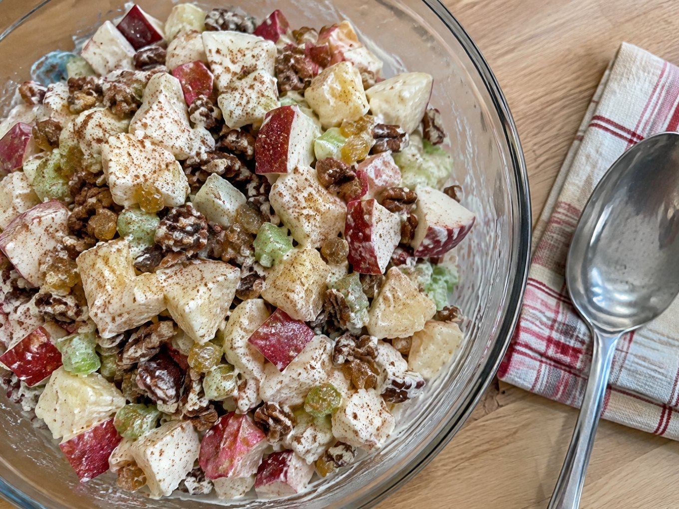 Ensalada de manzana navideña ligera con yogur griego, piña, apio, pasitas y nuez en bowl de cristal, receta fácil y saludable