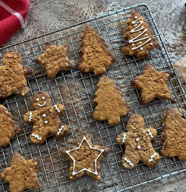 Galletas navideñas de jengibre con avena y miel enfriándose en rejilla, en forma de estrella, árbol y muñeco, receta saludable fácil