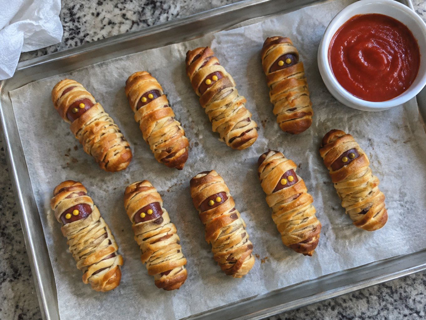 Momias de salchicha de pavo en masa integral doradas en charola con dip de jitomate, botana de Halloween fácil y saludable en air fryer