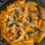 Pasta cremosa de calabaza y salvia con pollo dorado en sartén sobre la estufa, receta de pasta saludable y fácil para cena de otoño